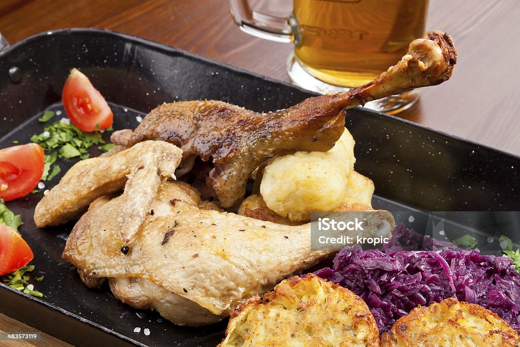Baked duck and chicken legs Baked duck and chicken legs with red cabbage, potato dumplings and potato pancakes Cabbage Stock Photo