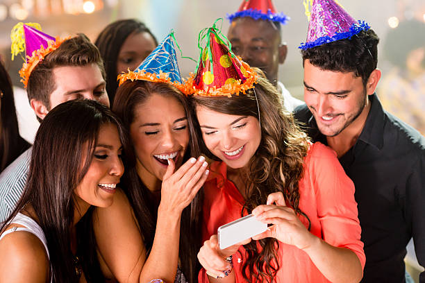 istock Party friends looking at a cell phone 483575283