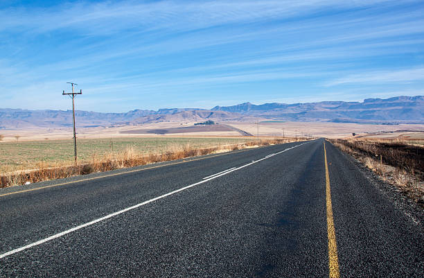 istock Straight Asphalt Road with Mountains in Background 483575350