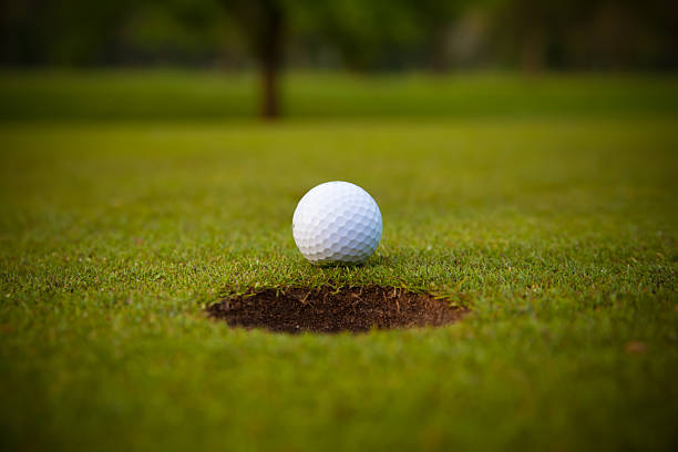 istock golf ball on lip of cup. 483575805