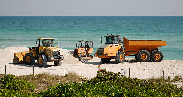 Construction trucks on beach stock photo