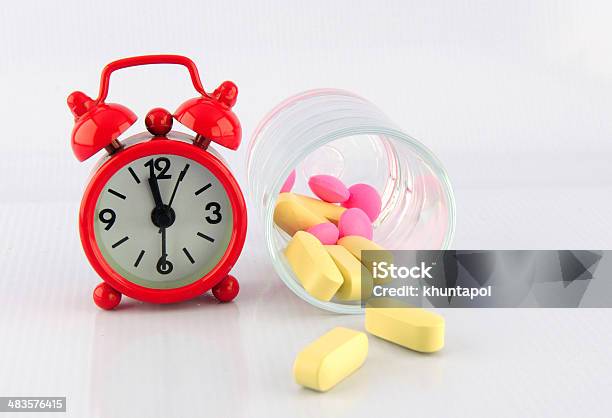 Red Clock And Tablet In Glass On White Background Stock Photo - Download Image Now - Backgrounds, Clock, Dose