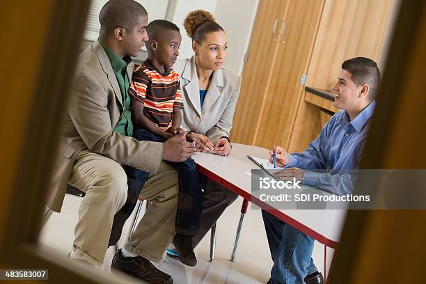 Padre Con Hijo De La Reunión Sobre El Comportamiento Con El Maestro En La Escuela Foto de stock y más banco de imágenes de Dia de los padres en el colegio