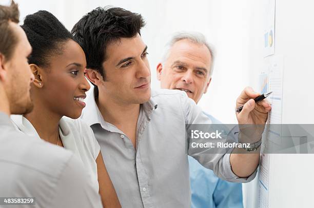 Business Team Analyzing Graph Stock Photo - Download Image Now - Graph, Meeting, Men