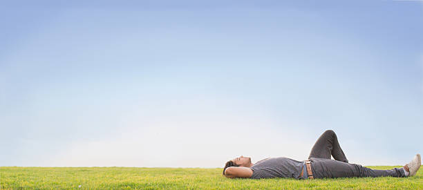 Relax Relaxed young man laying on grass. Blue sky man reclining stock pictures, royalty-free photos & images