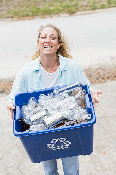 istock Woman carrying recycle bin 483585029