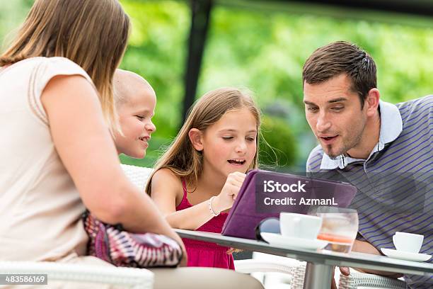 Familia En Un Café Foto de stock y más banco de imágenes de Adulto - Adulto, Agarrar, Aire libre