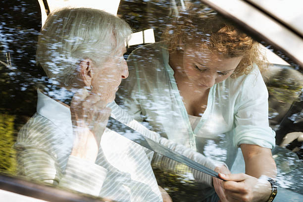 senior woman getting help in car