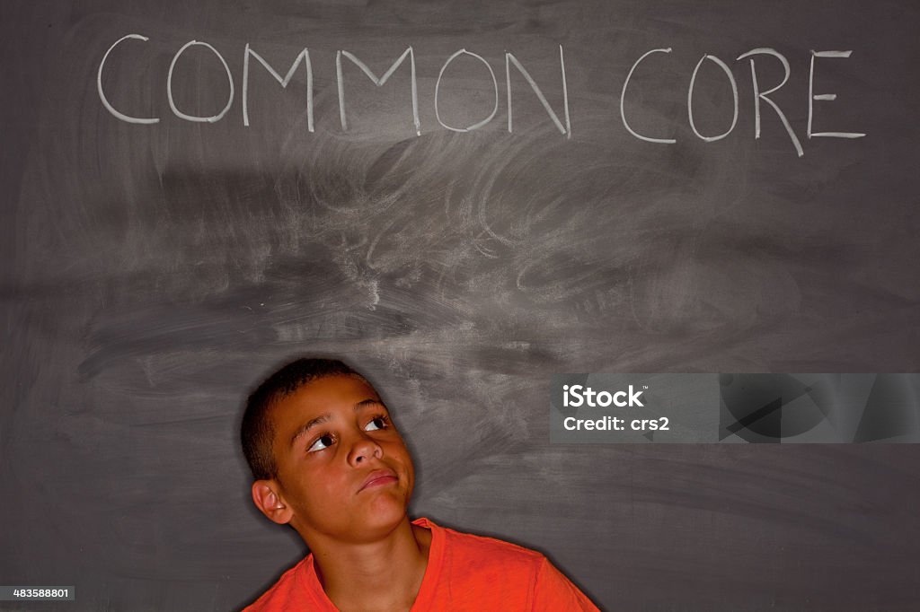 Criança de escola primária rapaz na frente de chalkboard com "comum" Núcleo - Royalty-free Aspiração Foto de stock