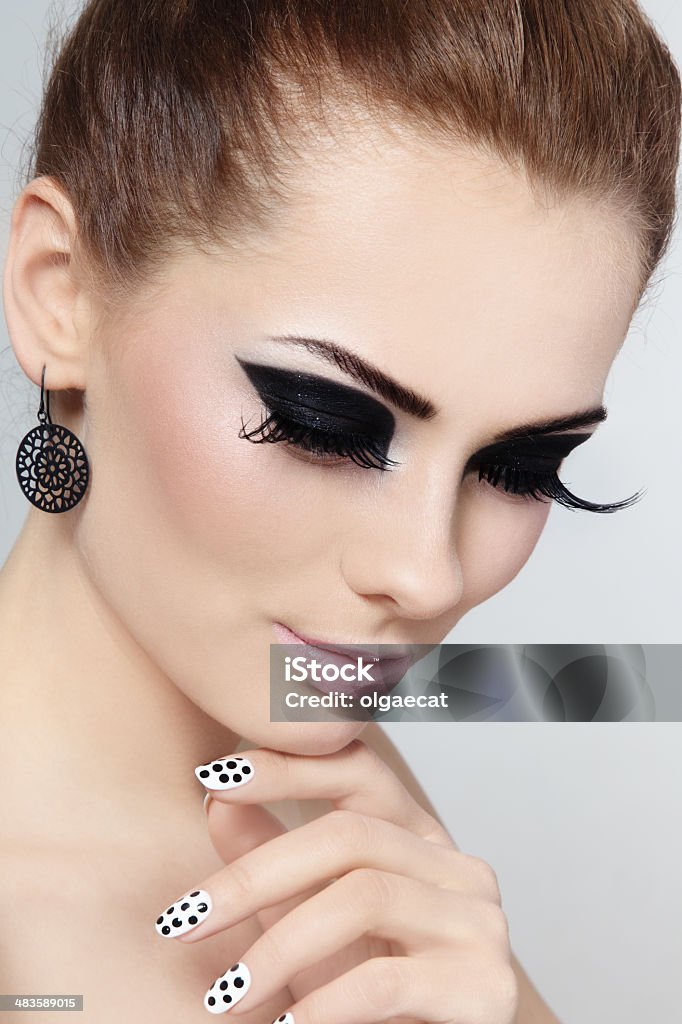 Make-up and manicure Close-up portrait of young beautiful girl with fancy cat eyes and polka dot manicure 1960-1969 Stock Photo