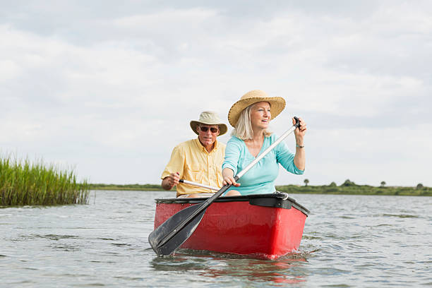 coppia senior in canoa sul intracoastal waterway, florida - men sitting canoe canoeing foto e immagini stock