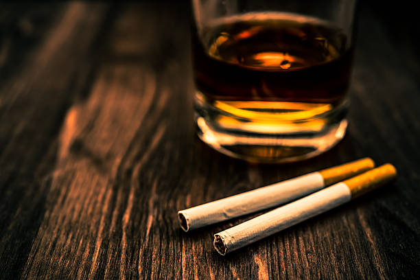 istock Glass of whiskey and two cigarettes 483592136