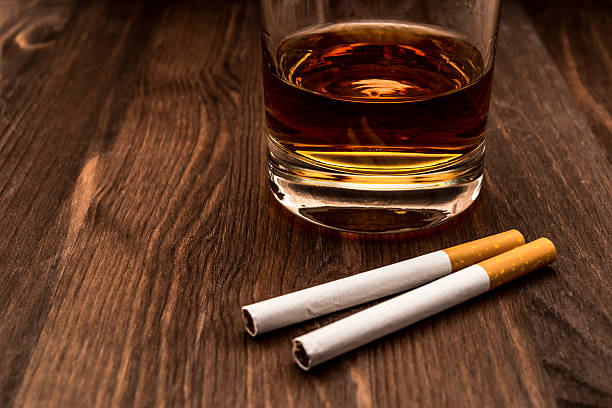 istock Glass of whiskey and two cigarettes 483592142