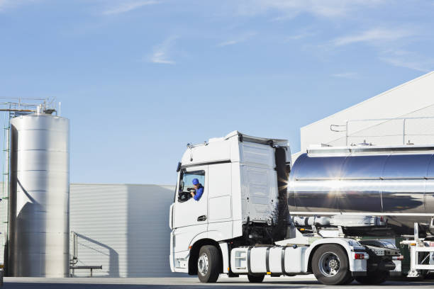 Truck driver parking stainless steel milk tanker outside silage storage tower  fuel tanker stock pictures, royalty-free photos & images