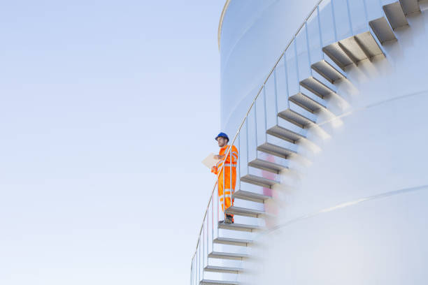 istock Worker with paperwork on stairs along silage storage tower 483596771