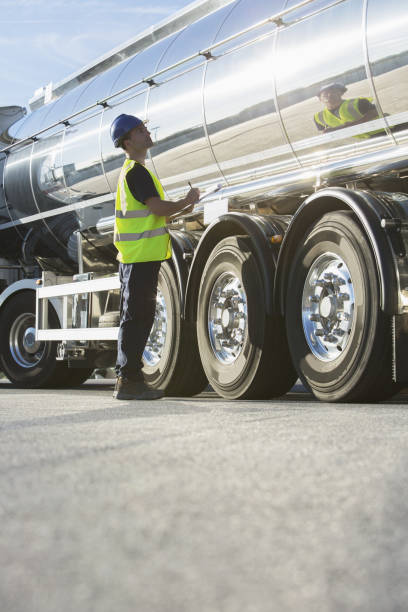 worker with clipboard checking stainless steel milk tanker - truck fuel tanker transportation mode of transport 뉴스 사진 이미지