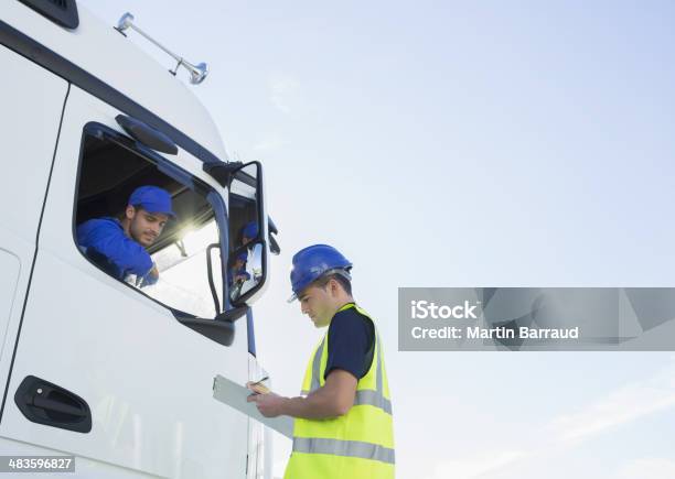 Worker With Clipboard Talking To Truck Driver Stock Photo - Download Image Now - Truck Driver, Talking, Freight Transportation