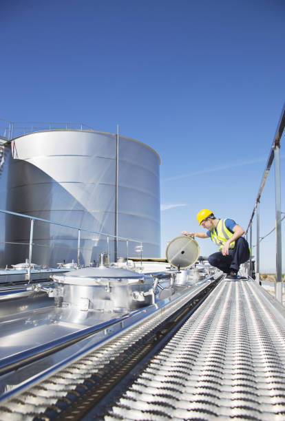 istock Worker on platform above stainless steel milk tanker 483596869