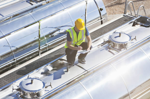 istock Worker using digital tablet on top of stainless steel milk tanker 483596911
