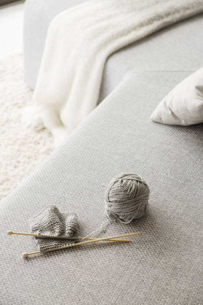 istock Knitting needles and ball of wool on sofa 483599017