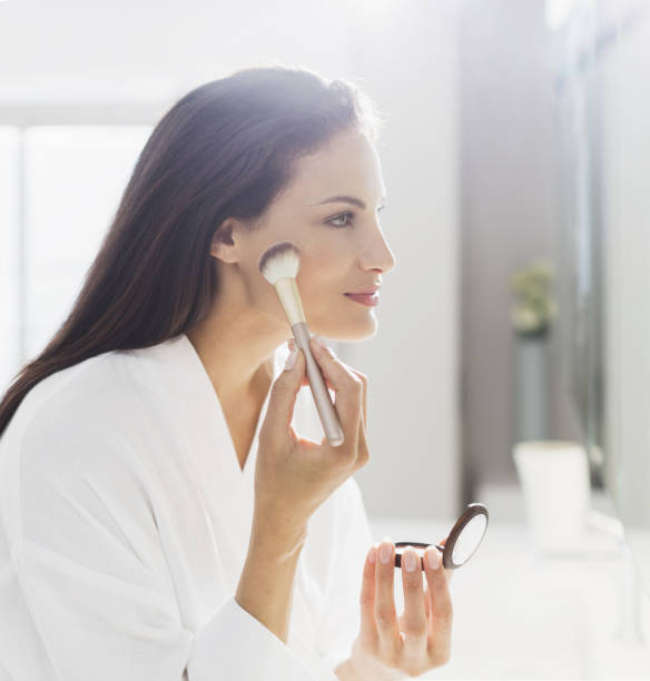istock Woman in bathrobe applying makeup in bathroom 483599105