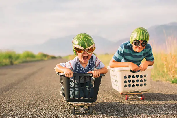 Photo of Young Boys Racing Wearing Watermelon Helmets