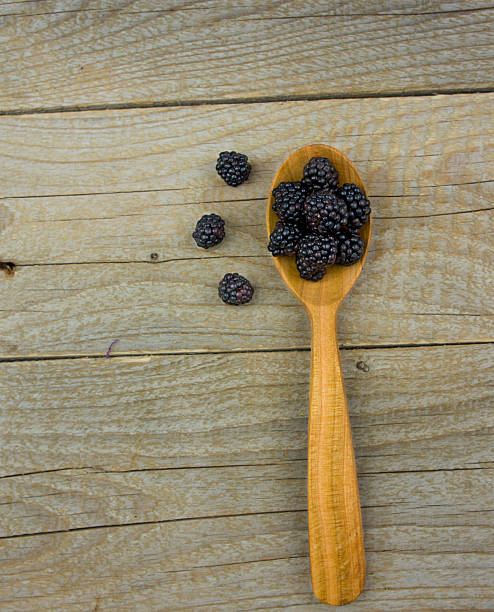 istock Blackberries with spoon on wooden background closeup shot 483604110
