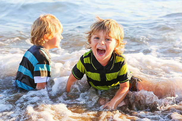 istock Two little blond kid boys having fun with wave 483606808