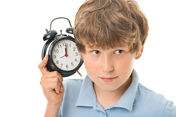 istock 11 years old boy with alarm clock 483608170