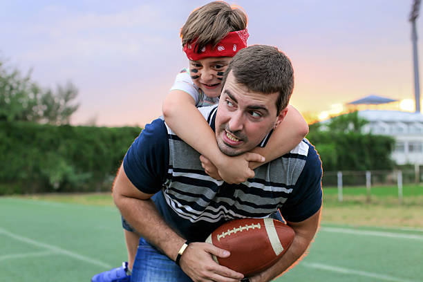 istock father and son playing American football 483608596