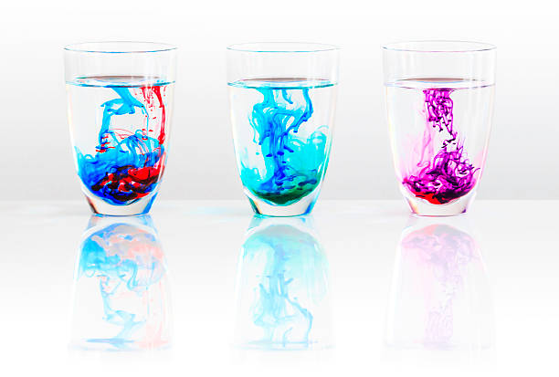 Three glasses of water and colored ink stock photo