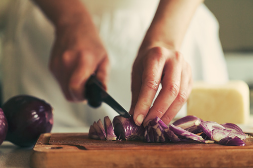 woman slicing red onion