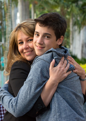 Mature woman embracing her teenage son