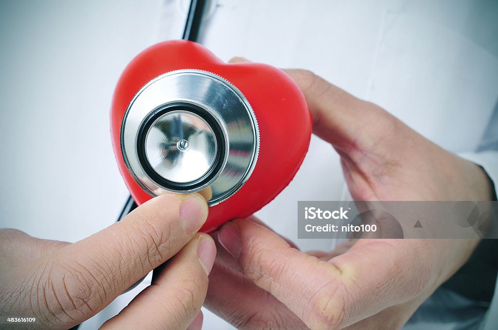 cardiovascular health a doctor auscultating a red heart with a stethoscope Adult Stock Photo