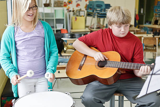 istock Girl and Boy Learning to Play Instruments 483619275