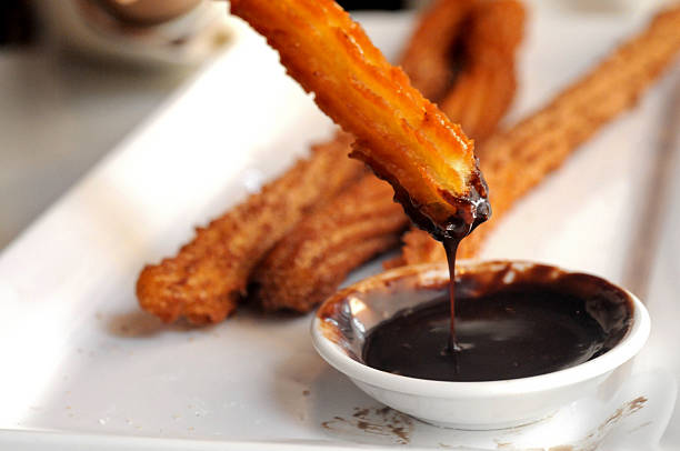istock Fried Spanish Churros dipping to warm chocolate sauce 483620895