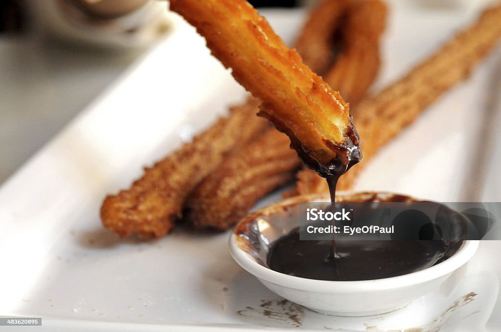 Fried Spanish Churros dipping to warm chocolate sauce Churro Stock Photo