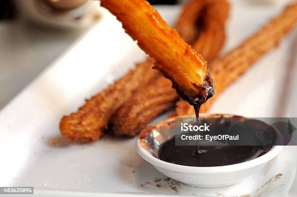 Fried Spanish Churros Dipping To Warm Chocolate Sauce Stock Photo - Download Image Now