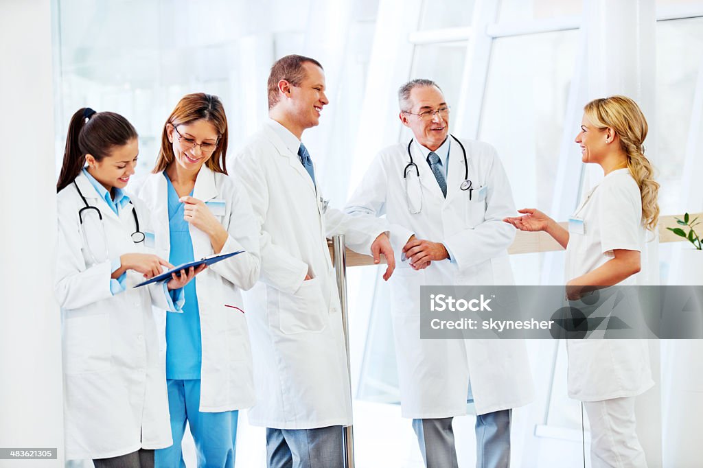 Group of successful doctors discussing. Cheerful successful doctors standing and discussing.    Adult Stock Photo