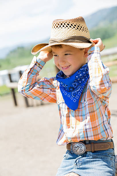 istock Adorable elementary age cowboy wearing western clothing at ranch 483621355