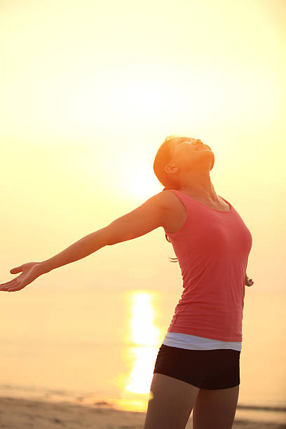 istock cheering woman open arms  at sunrise beach 483621535