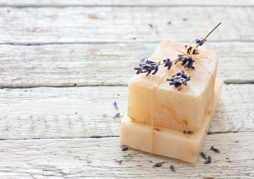 Handmade soap with lavender flowers over white grunge wood background