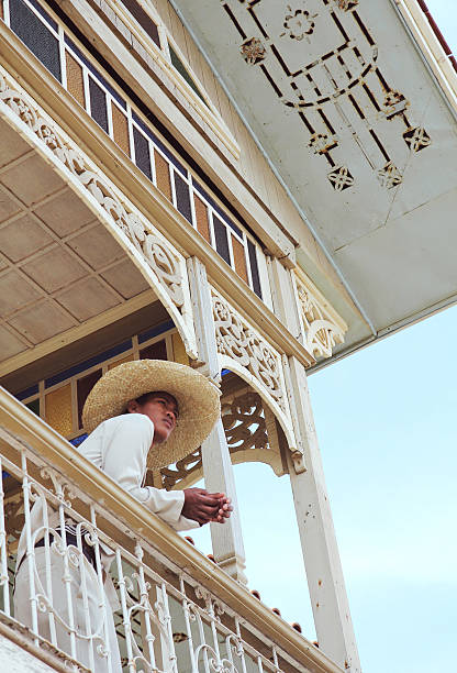 Bagac, Bataan, Philippines - October 26, 2012: A young Filipino man dressed in traditional garb looks out of a balcony of one of the many restored Spanish colonial houses in the heritage park, Las Casas Filipinas de Acuzar. 