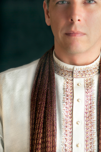A close-up shot of a peaceful man in traditional Indian clothing.