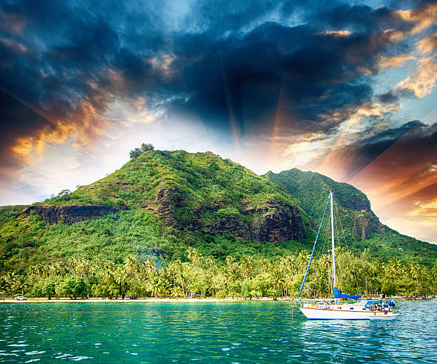 istock Polynesia. Island and vegetation at sunset with small boat 483631725