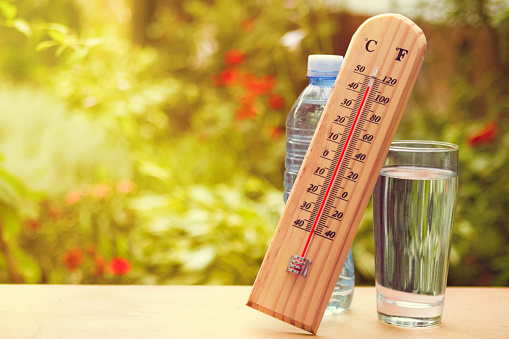 Thermometer on summer day showing high temperature near 45 degrees