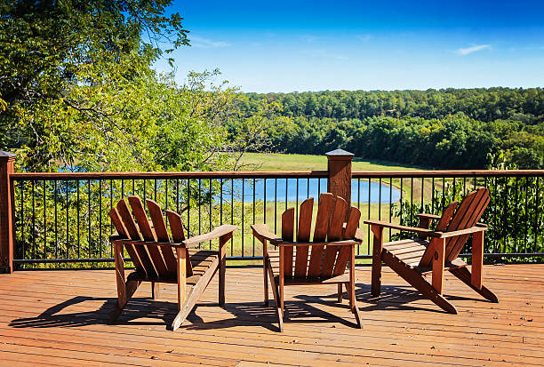 Three Chairs on a Deck Three adirondack chairs on a deck overlooking a lake boat deck stock pictures, royalty-free photos & images