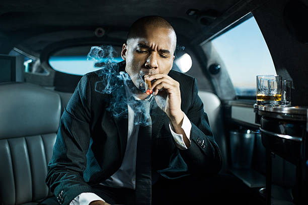 istock Businessman smoking a cigar in limousine. 483632617
