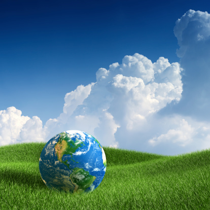 XXXL image of world globe Americas side laying on green grass. Concept image.