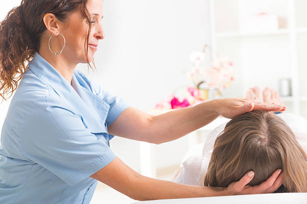 reiki de guérison - reiki alternative therapy massaging women photos et images de collection